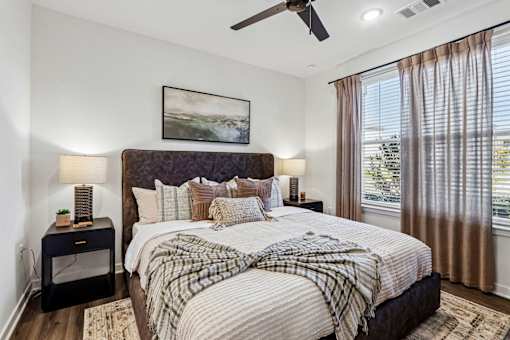 A bedroom with a large bed and a ceiling fan.