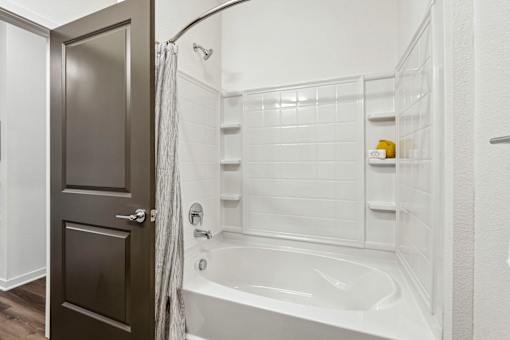 A white bathroom with a white tub and a white shower.