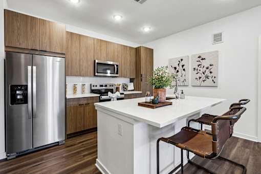 A modern kitchen with a stainless steel refrigerator and a white countertop.