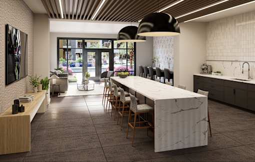 A modern kitchen with a long marble island and wooden chairs.