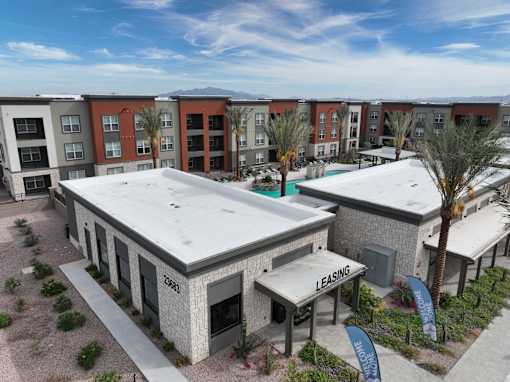 an aerial view of a building with a white roof and a pool at The Maddox Luxury Apartment Homes, Buckeye, AZ  