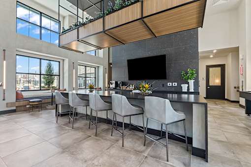 A modern kitchen with a bar area and a dining table.