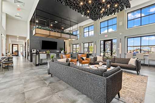 A modern living room with a grey sofa and a chandelier.