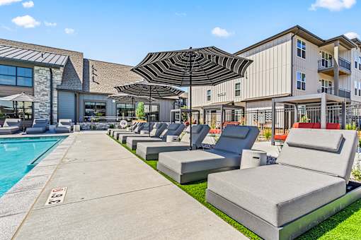 A poolside area with lounge chairs and umbrellas.
