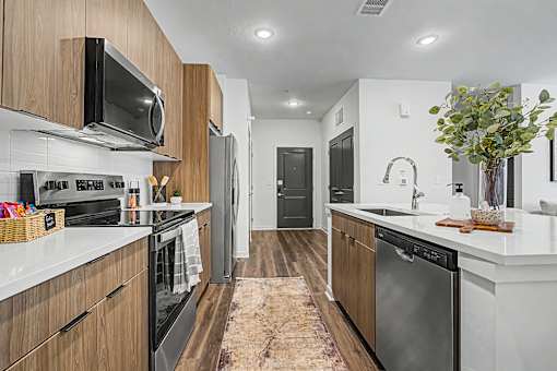 A modern kitchen with dark wood cabinets and stainless steel appliances.