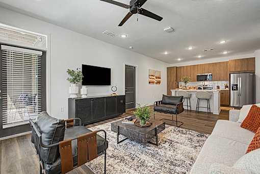 A modern living room with a black leather chair and a wooden coffee table.
