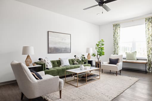 a living room with a green couch and chairs and a ceiling fan at Palm Grove in Ellenton, FL 34222