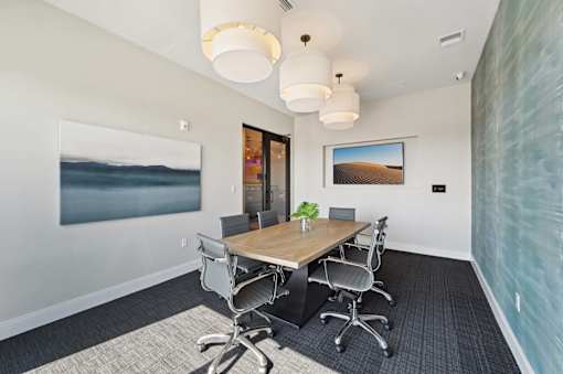A conference room with a long table and chairs.