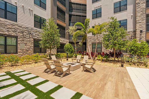 A patio with a table and chairs in front of a building.
