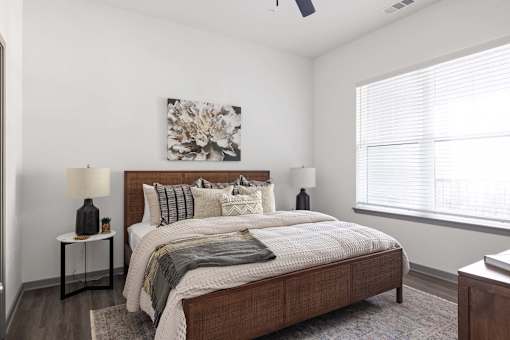 A bedroom with a large bed and a painting on the wall.