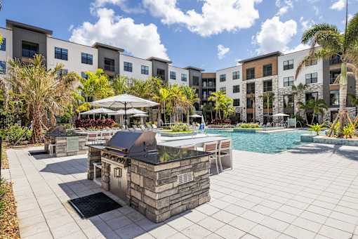 A pool area with a stone structure in the middle of a paved area.