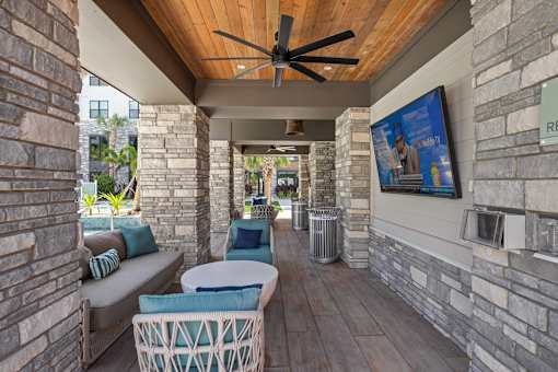 A patio with a ceiling fan and a couch.