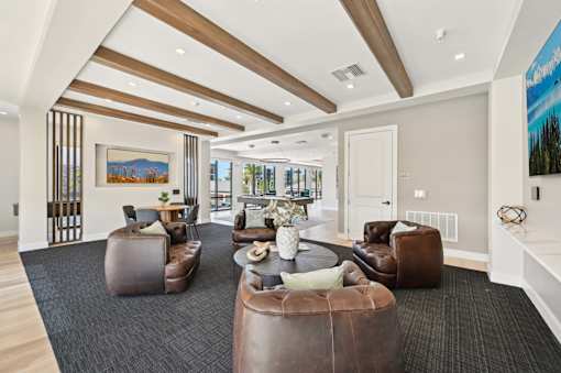 A living room with brown leather furniture and a painting on the wall.