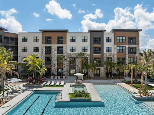 A large building with a pool in front of it.