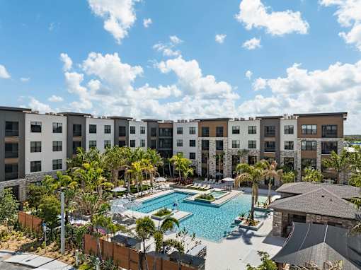 A large swimming pool is surrounded by apartment buildings.
