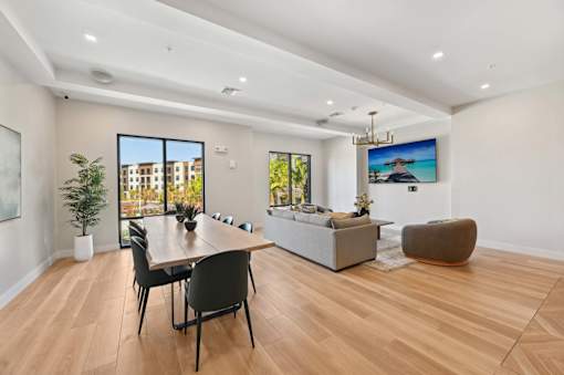 A modern living room with a dining table and chairs.