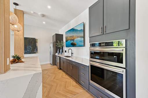 A modern kitchen with a large island and stainless steel appliances.