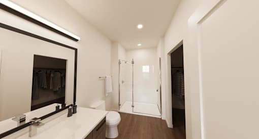 A white bathroom with a large mirror and a white toilet.