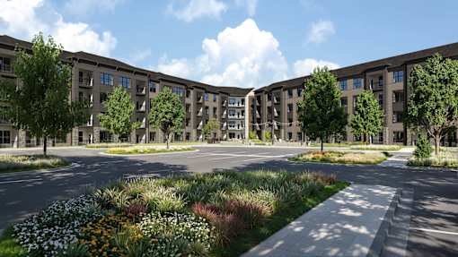A modern building complex with a landscaped courtyard in front.