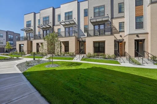 a view of the exterior of a building with green grass at Meridian at CityPlace in Woodbury, 55125