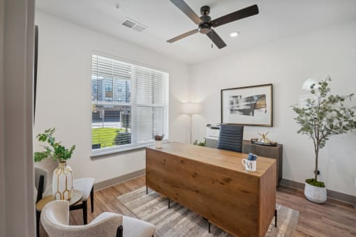 a living room with a desk and a ceiling fan at Meridian at CityPlace, Woodbury, MN