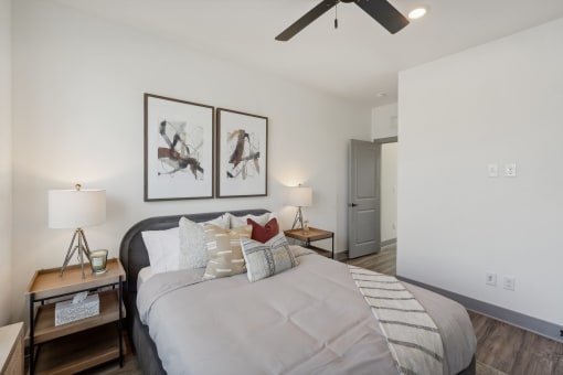 a bedroom with a large bed and a ceiling fan at Meridian at CityPlace, Woodbury, MN
