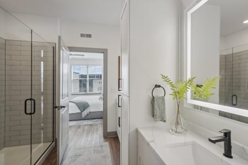 a white bathroom with a shower and a sink at Meridian at CityPlace, Woodbury, MN