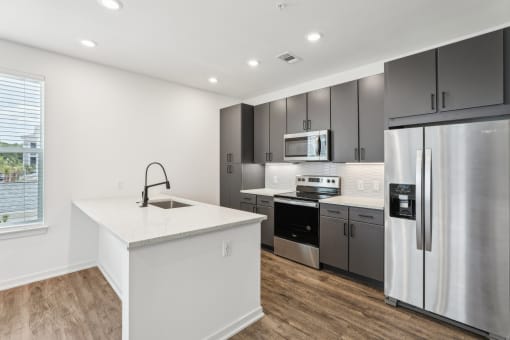 a kitchen with stainless steel appliances and a white counter top at Drift, Daytona Beach, FL, 32117