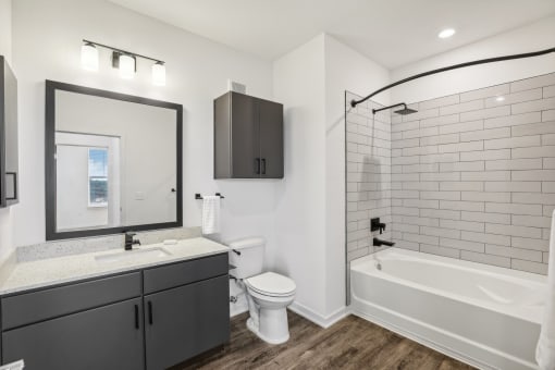a white bathroom with a large mirror and a white tub and sink at Drift, Daytona Beach, FL, 32117