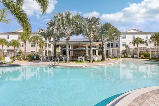 a large swimming pool with palm trees in front of a building at Drift, Daytona Beach, FL, 32117