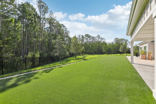a yard with green grass next to a house at Drift, Daytona Beach, FL, 32117