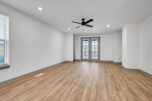 an empty living room with white walls and a ceiling fan at Meridian at CityPlace, Woodbury, 55125