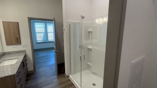 A bathroom with a walk-in shower and a window.