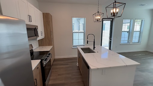 A kitchen with a white countertop and wooden cabinets.