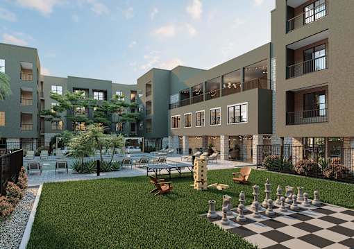 A chess board is set up on a grassy area in front of apartment buildings at Refinery at Pointe17 Apartments, Arizona, 85085