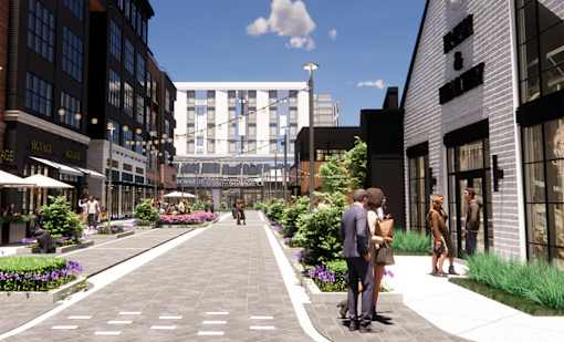 A street view of a city with people walking and talking at The Union Flats at Fishers District, Fishers, Indiana