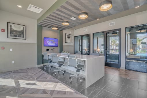 a conference room with a desk and chairs and a tv at Canter, Ocala, FL, 34474
