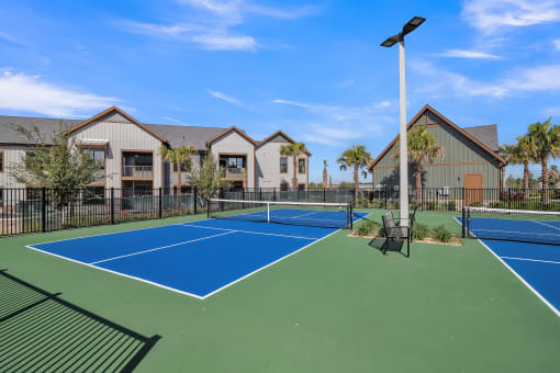 two tennis courts with apartments in the background at Canter, Ocala, FL