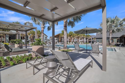 a patio with chairs and umbrellas next to a pool at Canter, Ocala, FL, 34474