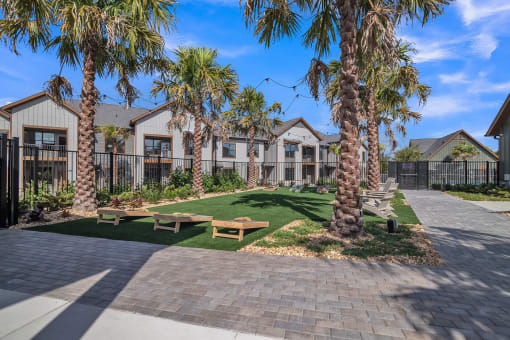 a picnic area with benches and palm trees in front of houses at Canter, Ocala, Florida