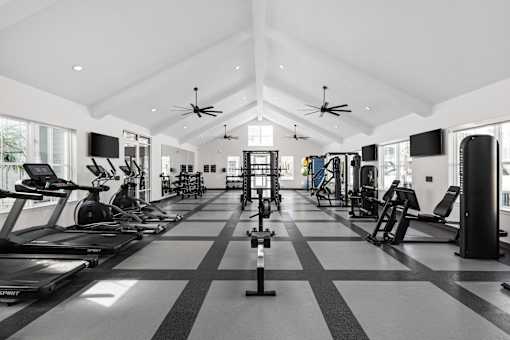 A spacious gym with treadmills, elliptical machines, and other exercise equipment.