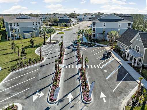 A street view of a residential area with a road and houses.