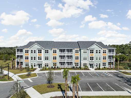 A large building with a parking lot in front.