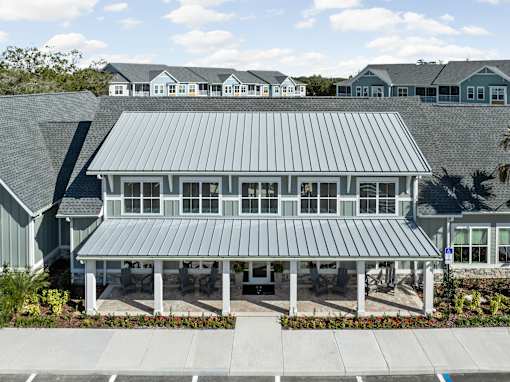 A large house with a grey roof and a covered patio.