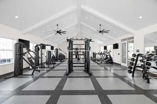 A spacious gym with a variety of equipment and a checkered floor.