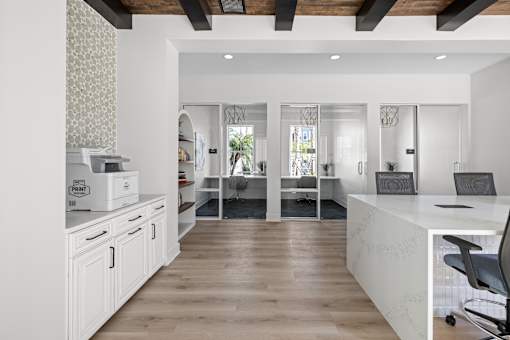 A white kitchen with a wooden floor and a white counter.
