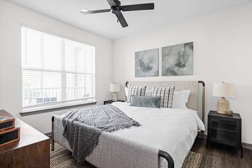 A bedroom with a large bed and a ceiling fan.