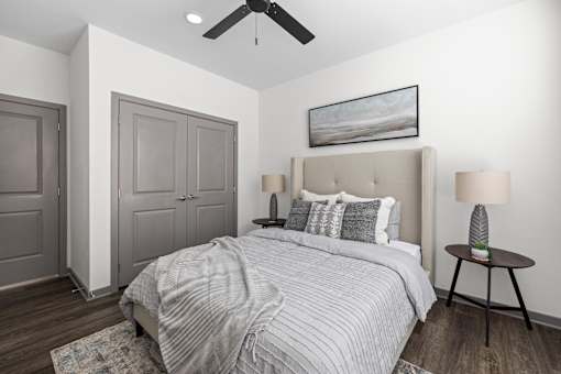 A bedroom with a large bed and a ceiling fan.