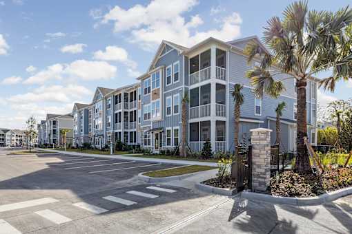 A large apartment complex with a parking lot in front.