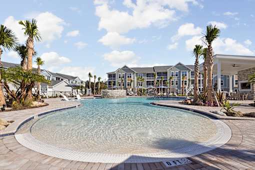 A large swimming pool in front of a resort.